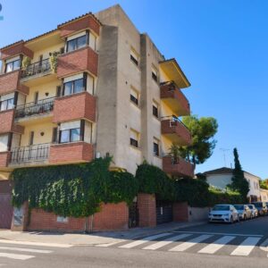 Edifici amb tres pisos i solar per edificar